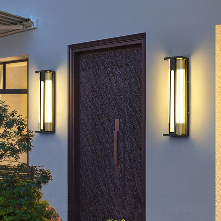 Two amber lanterns lit on either side of a tall dark wood front door