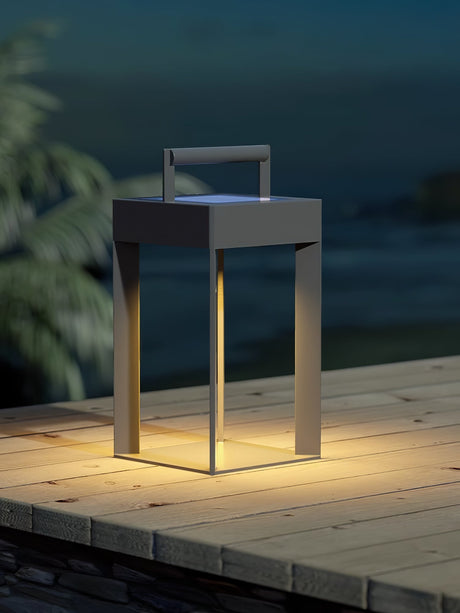 The lantern glowing at the edge of a timber deck at dusk by the water