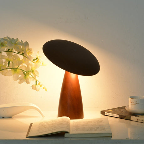Portable table lamp lit beside white orchids and a book