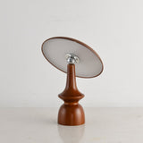 Portable table lamp on a spindle base with the disc tilted