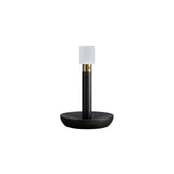 Portable table lamp in black standing on a plain white ground