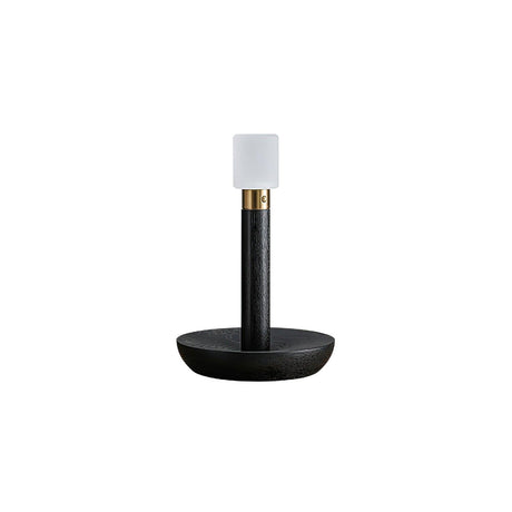 Portable table lamp in black standing on a plain white ground