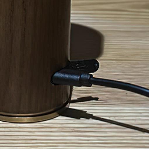 Charging cable plugged into the port on the edge of the wood dish base