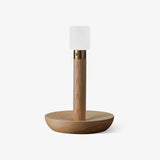 Portable table lamp with a light wood dish base and a small acrylic cap