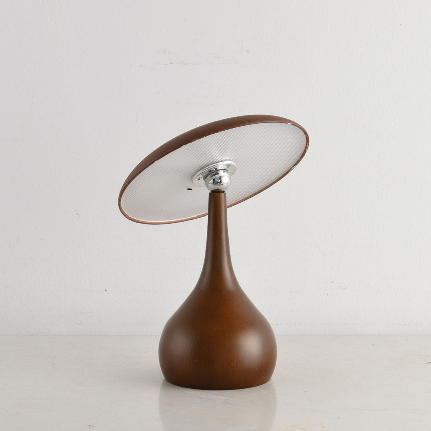 Portable table lamp on a teardrop base, the disc face lit
