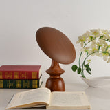 The disc of the portable table lamp tilted steeply over to one side