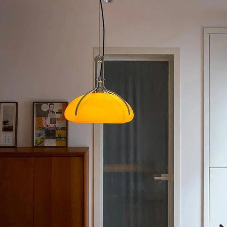 The orange shade lit in a room beside a door and a wooden cabinet