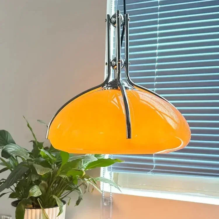 The orange shade lit in a corner above a plant beside a pale wall