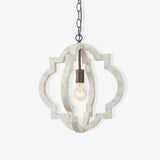 A quatrefoil frame of aged white wood around a single filament lamp on a chain