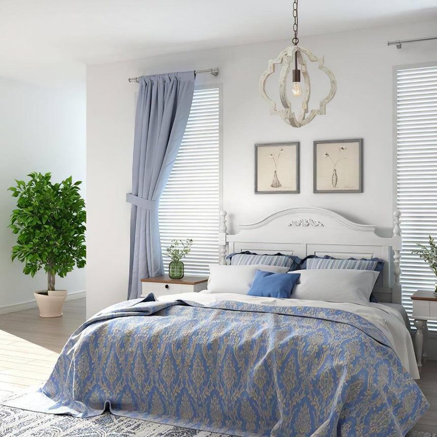 Hung in a bedroom above a bed with blue bedding, curtains and framed prints