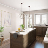 Two of them lit above a dark kitchen island with stools and a window behind