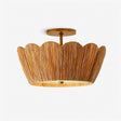 Raffia ceiling light with a handwoven scalloped shade and brass detail on a plain background