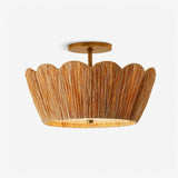 Raffia ceiling light with a handwoven scalloped shade and brass detail on a plain background