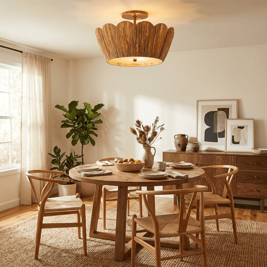 Raffia ceiling light lit above a round dining table with wood chairs and a plant