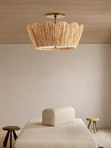 Raffia ceiling light above a pale sofa in a room with a small wood stool