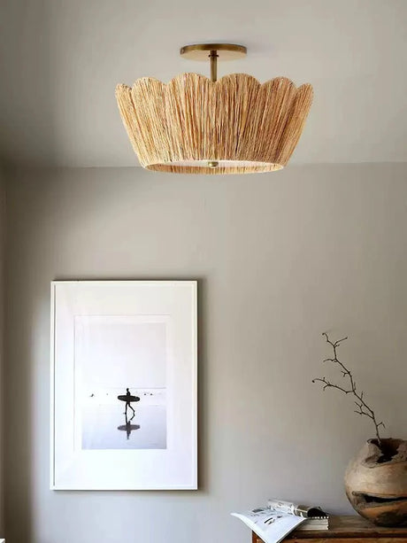 Raffia ceiling light lit near a framed print and a ceramic vase on a shelf