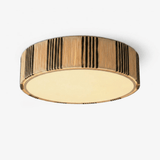 Raffia ceiling light with a striped woven drum shade and a brass rim