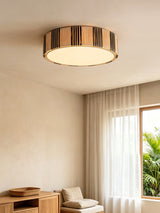 Striped raffia drum ceiling light in a room with a wood cabinet and open curtains