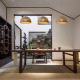 Open woven rattan dome hung in a room with pale walls