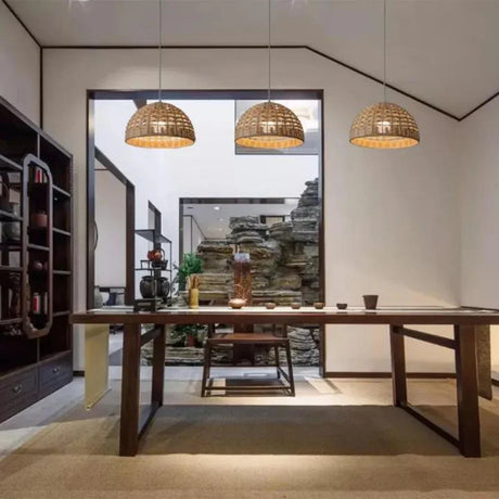 Open woven rattan dome hung in a room with pale walls