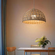 Rattan ceiling light with an open woven dome shade lit in a warm interior