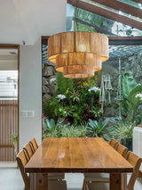 Rattan drum pendant light hung over a wooden dining table