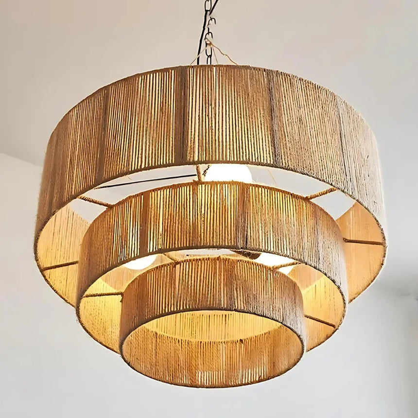 Rattan drum pendant light seen from below, the tiers lit as concentric rings