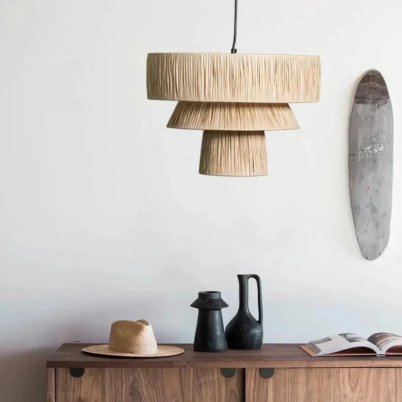 Rattan drum pendant light above a sideboard beside a round mirror