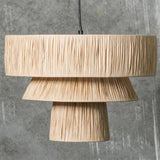 Rattan drum pendant light in natural straw against a gray background