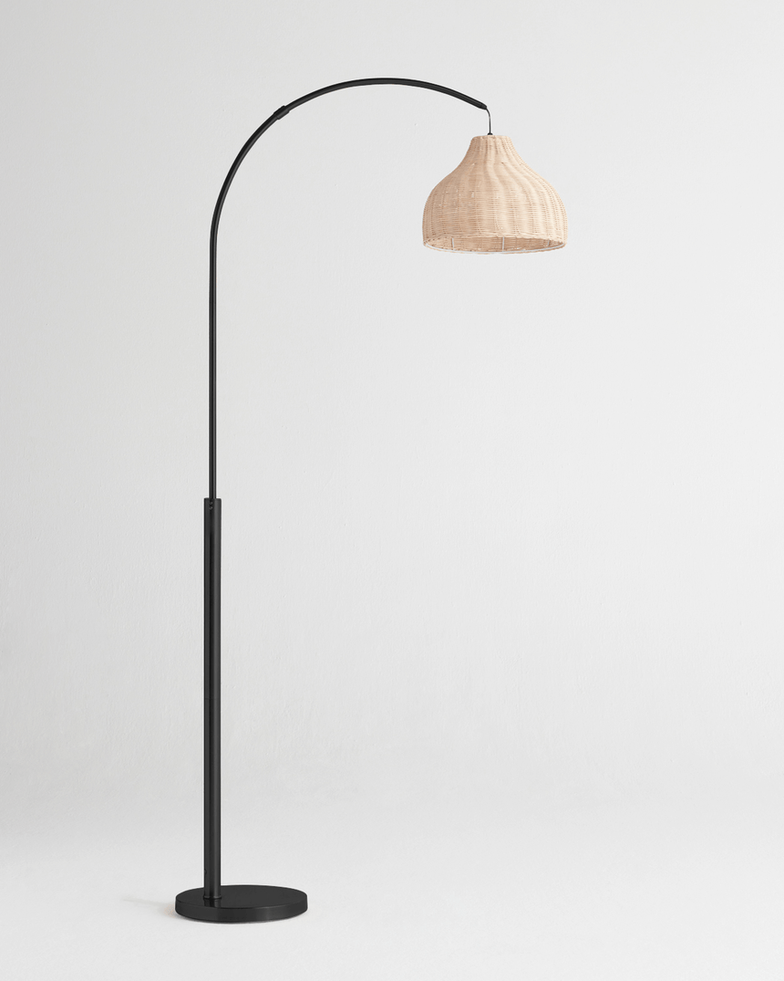 The same arc in black, the pale woven shade hanging from the curved stem