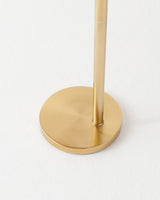 The brass pole set into a low round disc base on a pale floor