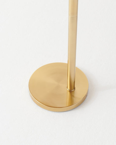 The brass pole set into a low round disc base on a pale floor