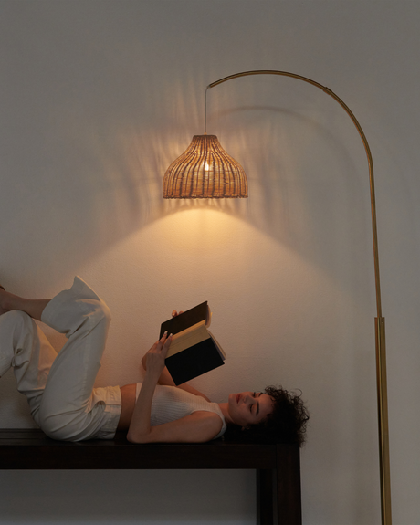 The wicker shade lit warm over a dark wood bench with two readers under it