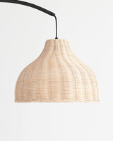 The same woven shade on a black cord, the ribs of the weave lit from within