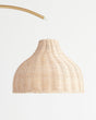 The woven wicker shade seen close, the open weave and the brass arm above