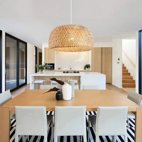 Rattan hanging lamp with a woven bamboo dome lit above a table