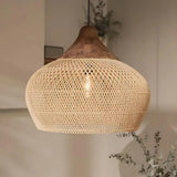 Rattan hanging light in a woven bell shape, natural finish, above a counter