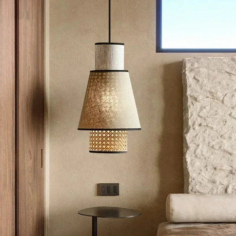 Woven rattan pendant hung in a living room against a stone wall