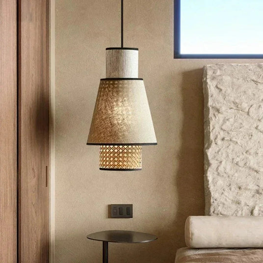 Woven rattan pendant hung in a living room against a stone wall