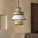 Rattan hanging light with a woven upper band and a fabric lower band, lit in a room