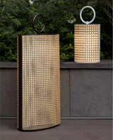The lantern lit beside a concrete garden wall with a smaller one above