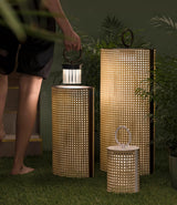 Two sizes lit on a lawn at dusk with planting and a garden path behind