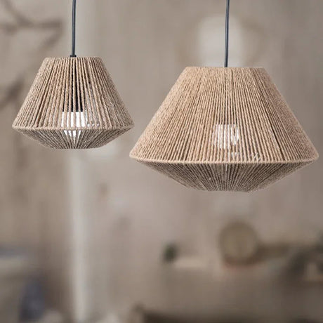 Rattan pendant lamp with a pleated woven shade lit against a pale wall