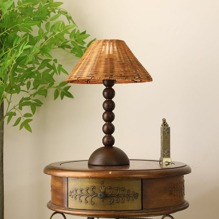 Rattan shade lamp lit close up, the weave catching the light