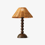 Table lamp with a woven rattan shade on a beaded walnut base