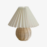 Rattan table lamp seen in full against a plain pale ground