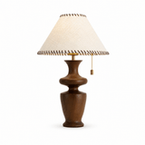 Table lamp with a woven fabric shade and leather trim, plain background