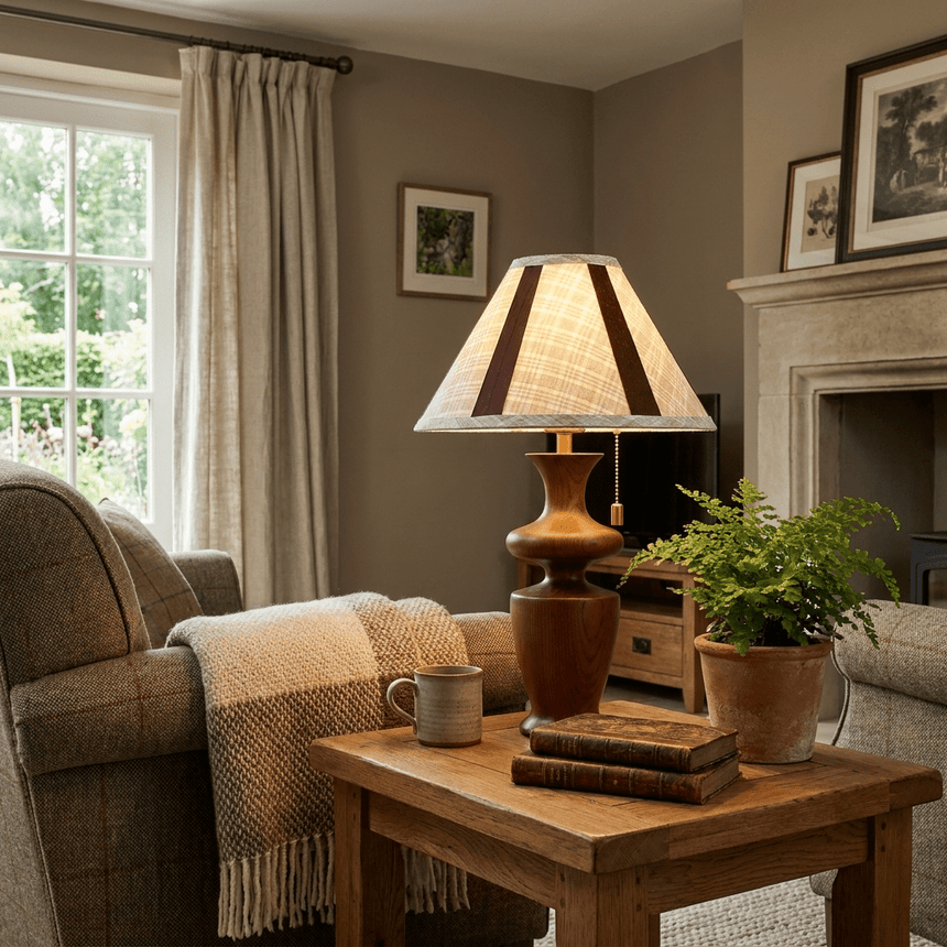 Plaid shade table lamp lit on a side table beside a sofa and a plant