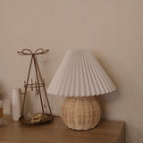 Rattan table lamp on a chest beside a wire jewelry stand