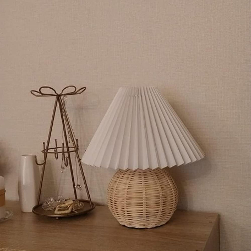 Rattan table lamp on a chest beside a wire jewelry stand